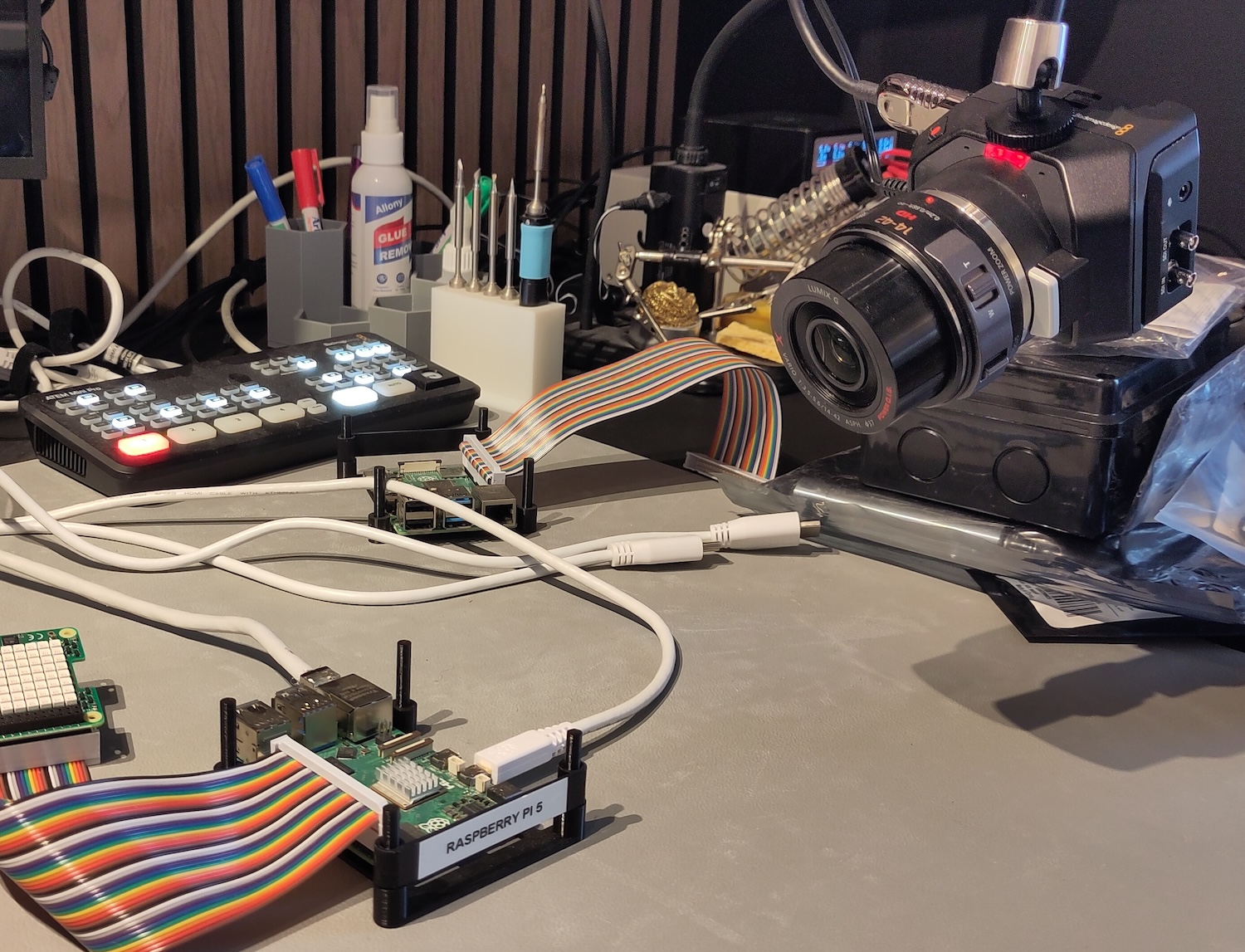 The experimentation desk: an ATEM Mini, a bunch of Raspberry Pi's, and the Micro Studio Camera with its tally light on